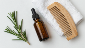 Rosemary oil dropper bottle with fresh rosemary and a wooden comb
